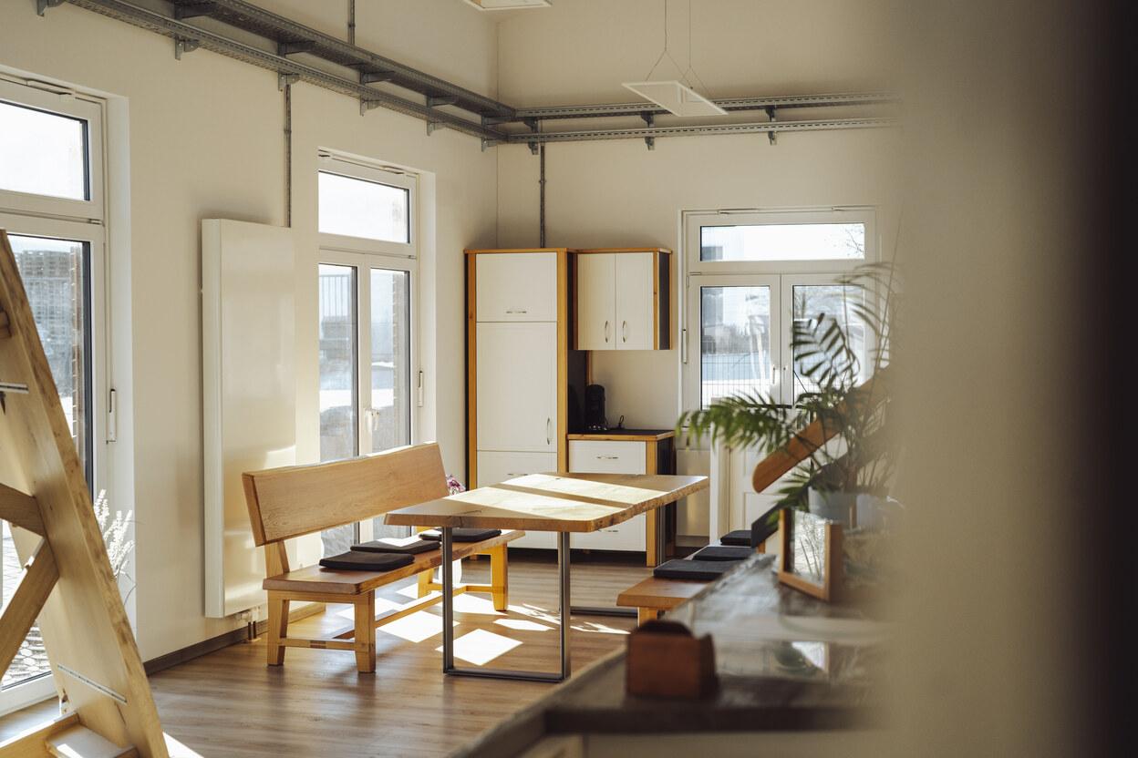 Besprechungstisch aus massiver Eiche in einem lichtdurchfluteten IDEEN REICH mit weißer Wandfarbe