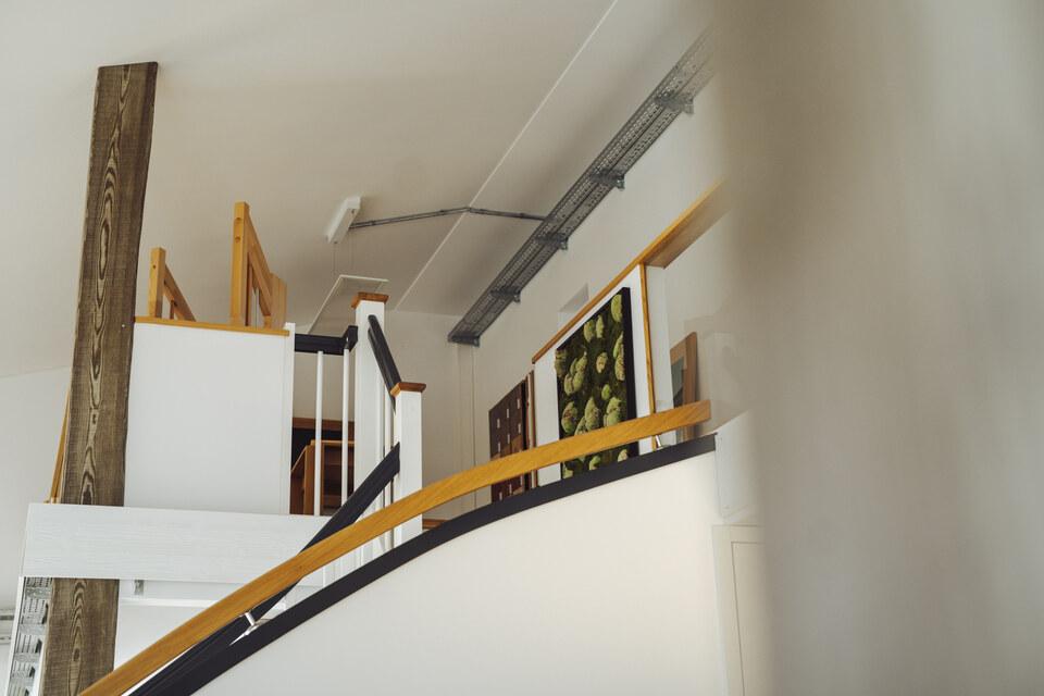 Ansicht von unten nach oben auf den Treppenbereich des IDEEN REICHs in weiß und holzfarbend gehalten