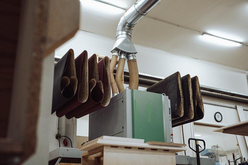 im Zentrum des Bildes befindet sich eine Schleifmaschine mit dazugehörigem Schmirgelpapier