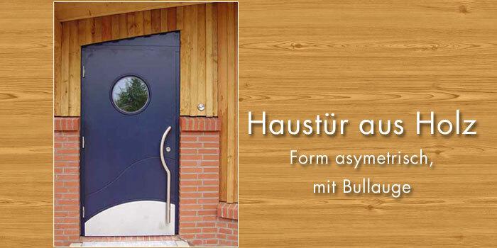 Eine stilvolle, asymmetrisch geformte dunkelblaue Holzhaustür mit einem runden Bullauge, umgeben von einer hölzernen und gemauerten Fassade.
