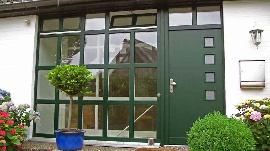 Eingangsbereich Haus Impression eines Eingangsbereichs von außen mit einer grünen Tür und Glaseinsätzen daneben