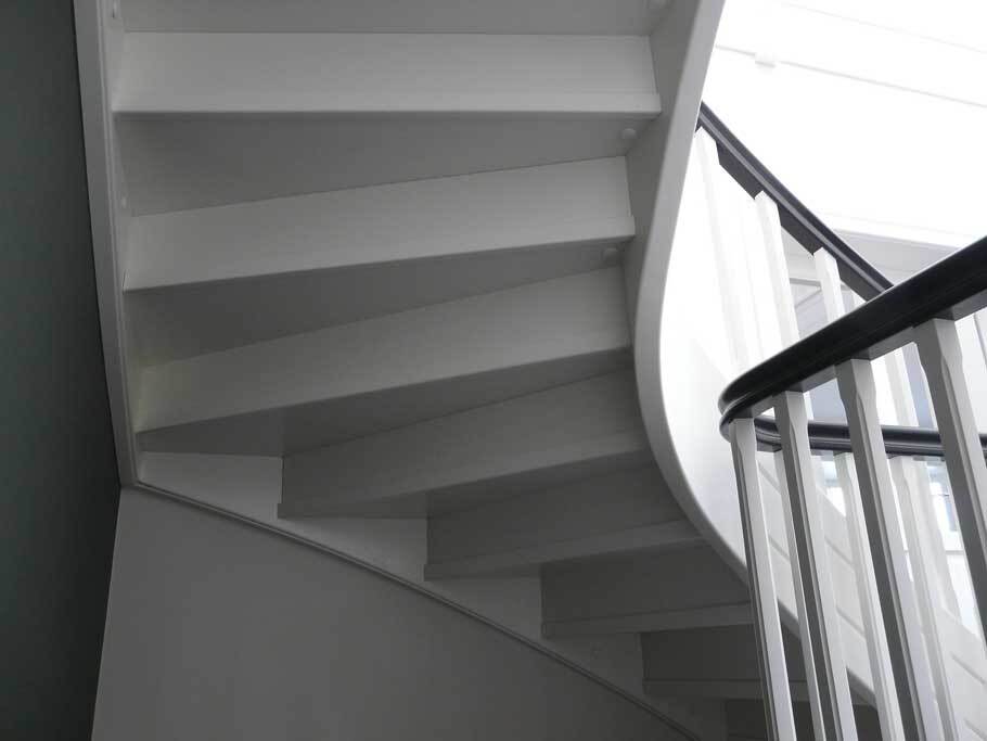 Aufwärtsblick in eine Wendeltreppe mit schlichtem Design und hellem Interieur