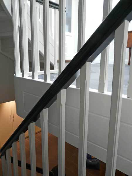 Geländer einer Holztreppe Detailaufnahme eines weißen Treppengeländers mit schwarzem Handlauf