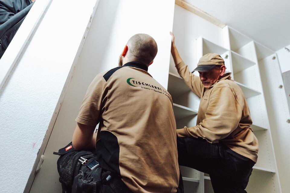 Montage maßgefertigter Einbauschränke vor Ort Zwei Tischler der Tischlerei Lohse montieren passgenaue Einbauschränke in einem Raum und sorgen für eine präzise Anpassung an die Gegebenheiten.