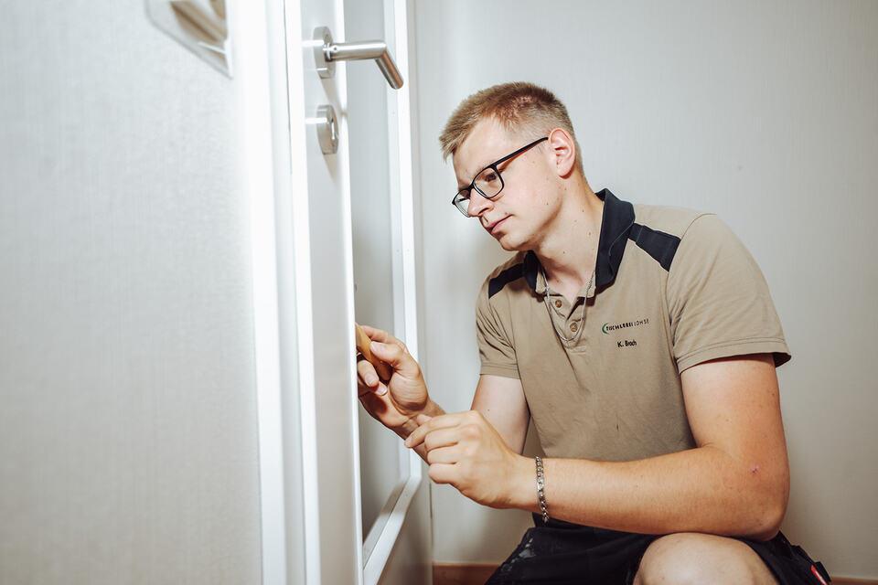 Ein Mitarbeiter der Tischlerei Lohse montiert eine Innent&uuml;r