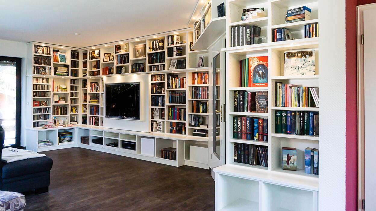 Eine große Mediaregalwand aus Holz mit Büchern und einem Fernseher