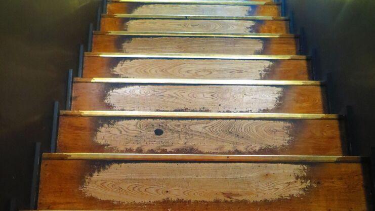 Treppensanierung Holztreppen mit ausgetretenen Holzstufen zwischen dunklen Wänden