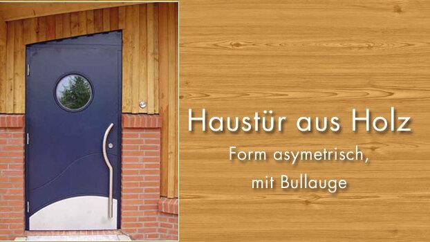 Moderne asymmetrische Holzhaustür mit Bullauge Eine stilvolle, asymmetrisch geformte dunkelblaue Holzhaustür mit einem runden Bullauge, umgeben von einer hölzernen und gemauerten Fassade.