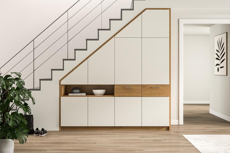Intelligente Stauraumlösung unter einer Treppe mit einem maßgefertigten Schrank in Cremeweiß und Holzoptik, ideal für die aufgeräumte Gestaltung des Eingangsbereichs.
